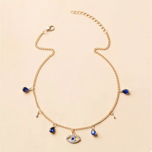 Gold evil eye charm necklace with blue crystal teardrops and key charms