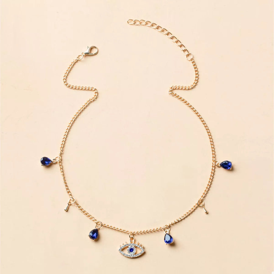 Gold evil eye charm necklace with blue crystal teardrops and key charms