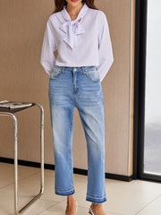 Whiskered wash cropped jeans in light blue denim with frayed hem detail.