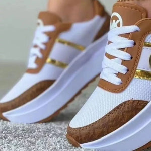 Chic round toe platform sneakers in white with brown accents and gold detailing.