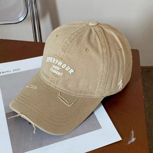 Khaki distressed baseball cap with white embroidered text and distressed brim.