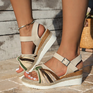 Beige espadrille platform sandals with knotted detail and ankle strap.