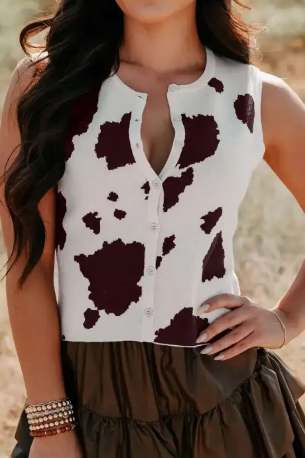 Chic cow print button-down sweater vest with crew neck and button closure.