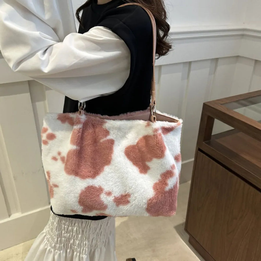 Dusty pink cowhide print faux fur shopper bag with pink trim and leather straps.