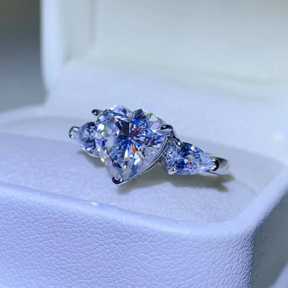 Silver heart-cut diamond trilogy ring with pear-shaped side stones.