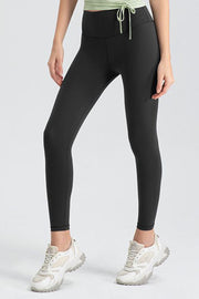 Black high-waist performance leggings with drawstring detail and sculpted seams.