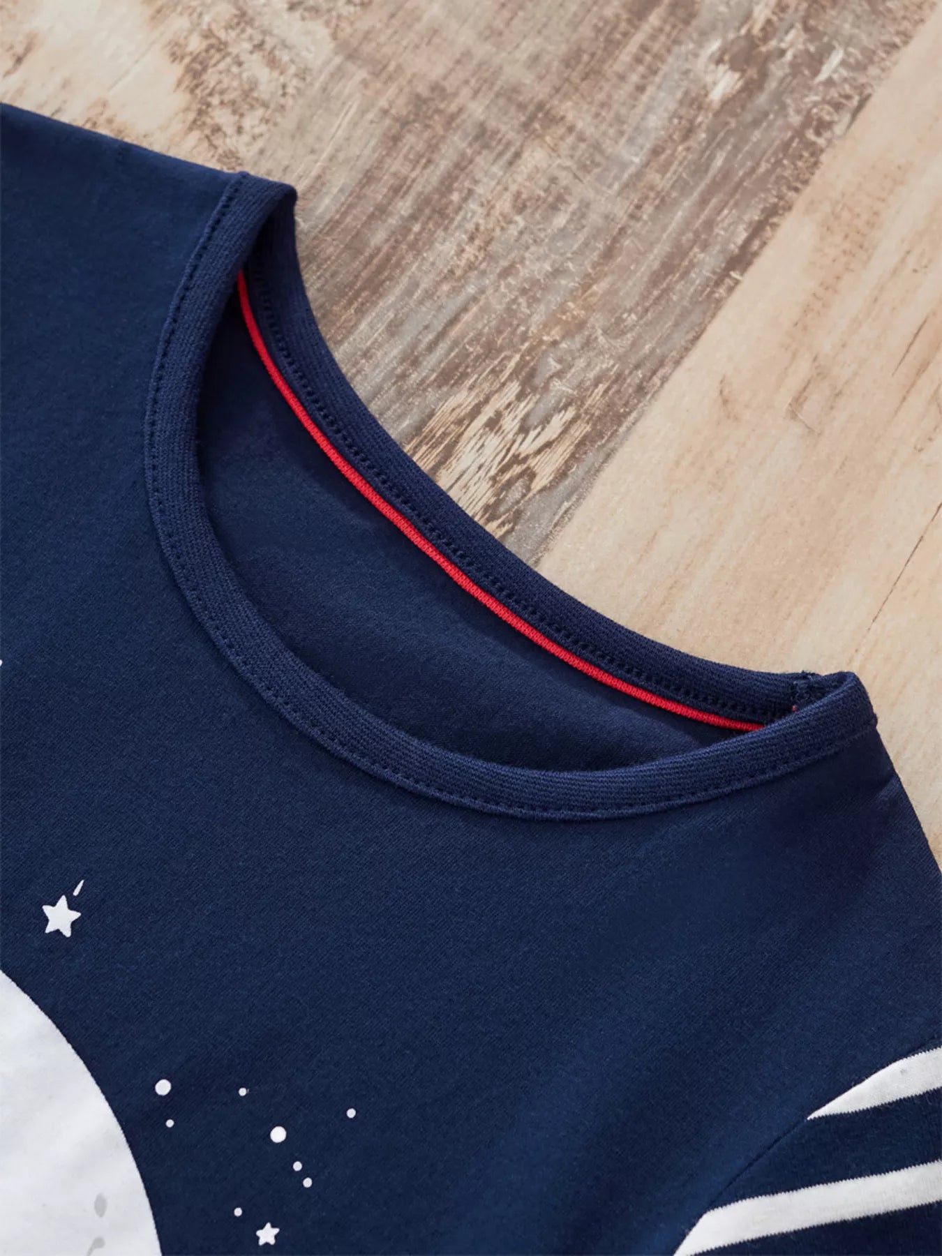 Dark navy 100% cotton long-sleeve tee with Santa sleigh graphic and red neck trim detail.