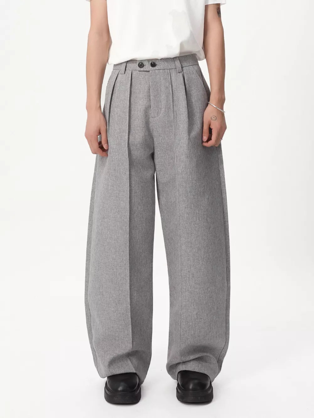 Gray relaxed wide-leg pleated trousers with a high waist and button closure.
