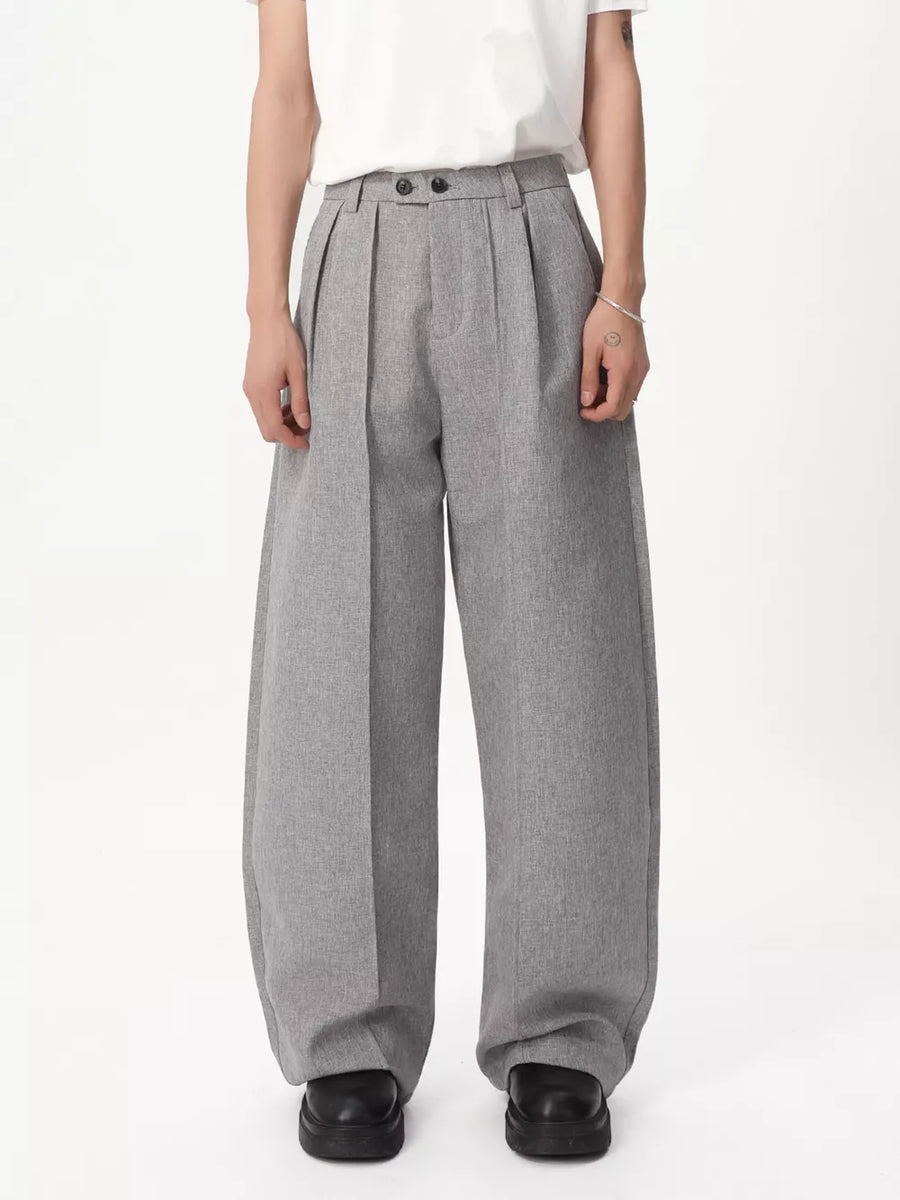 Gray relaxed wide-leg pleated trousers with a high waist and button closure.