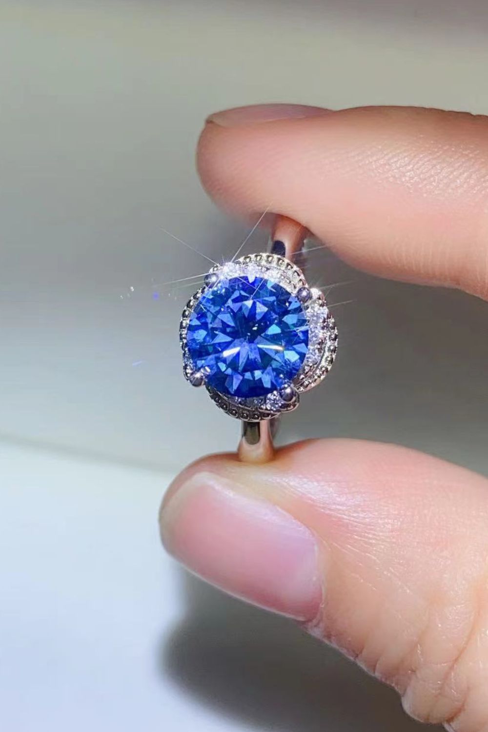 Blue moissanite cocktail ring with a halo of small diamonds.
