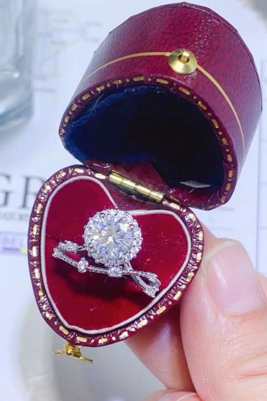 Diamond halo ring with twisted band in a heart-shaped box