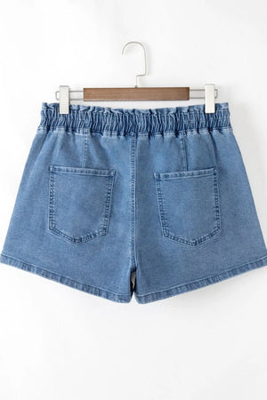 Medium wash denim shorts with paperbag waist and relaxed fit.