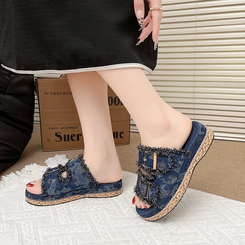 Denim fringe platform slides in navy with double buckle straps and a espadrille sole.