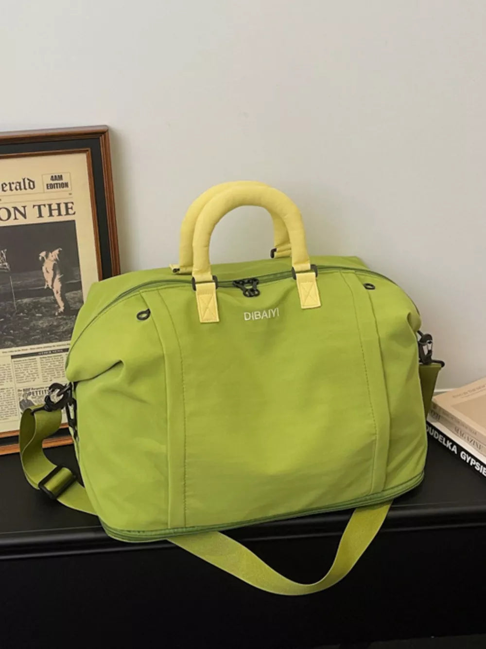 Green nylon travel bag with yellow handles and adjustable strap