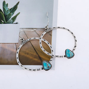 Southwestern stone hoop earrings in silver with turquoise accents and tribal patterns.
