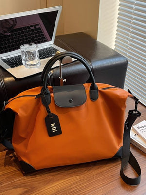 Orange duffel bag with black trim, top handles, and detachable strap.