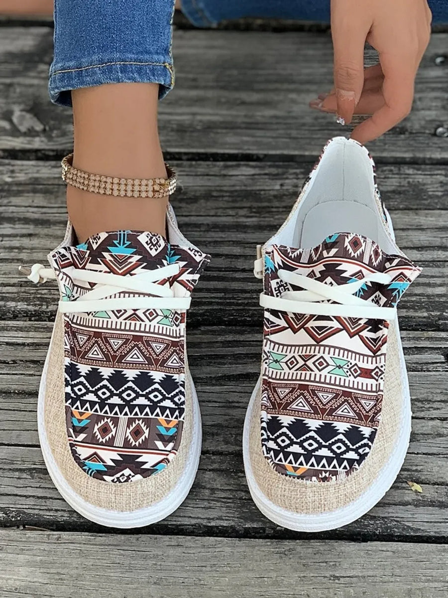 Aztec print canvas slip-on flats with white laces and tan canvas uppers.