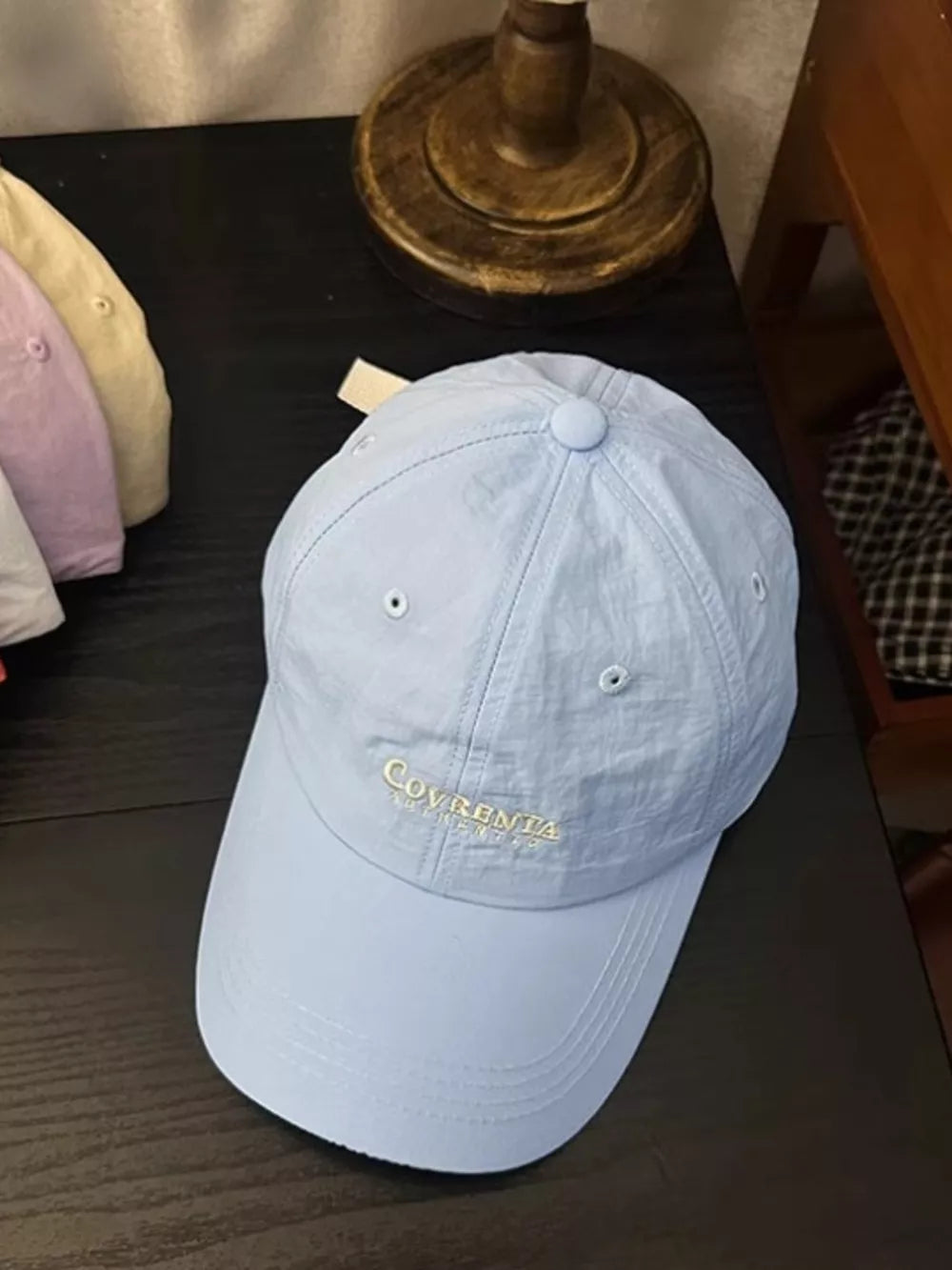 Sky blue cotton baseball cap with embroidered text detail and curved brim.