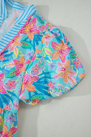 Tropical floral print v-neck dress with scalloped trim and blue striped collar detail.