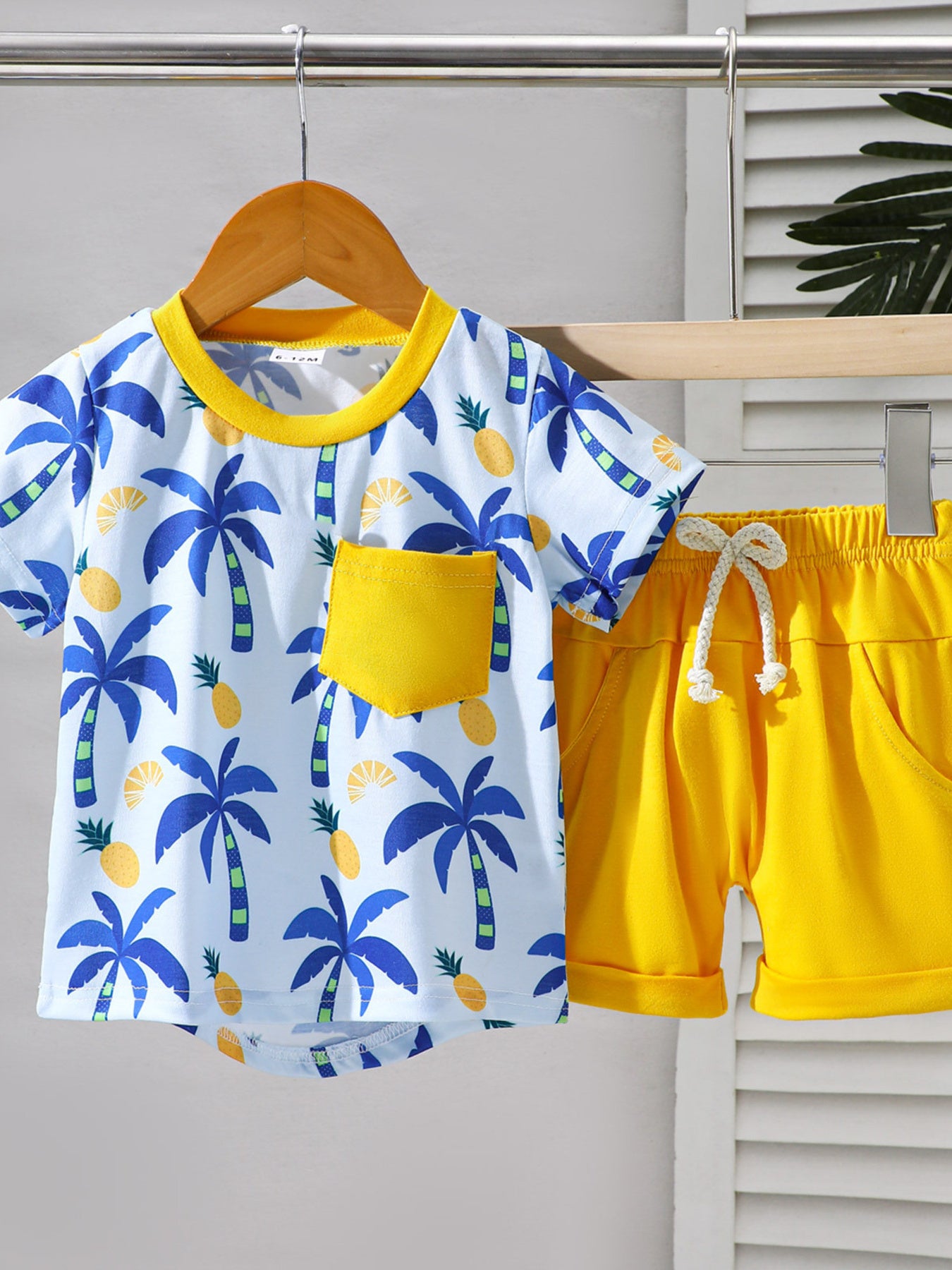 Baby tee and shorts set with tropical palm tree print and yellow accents.