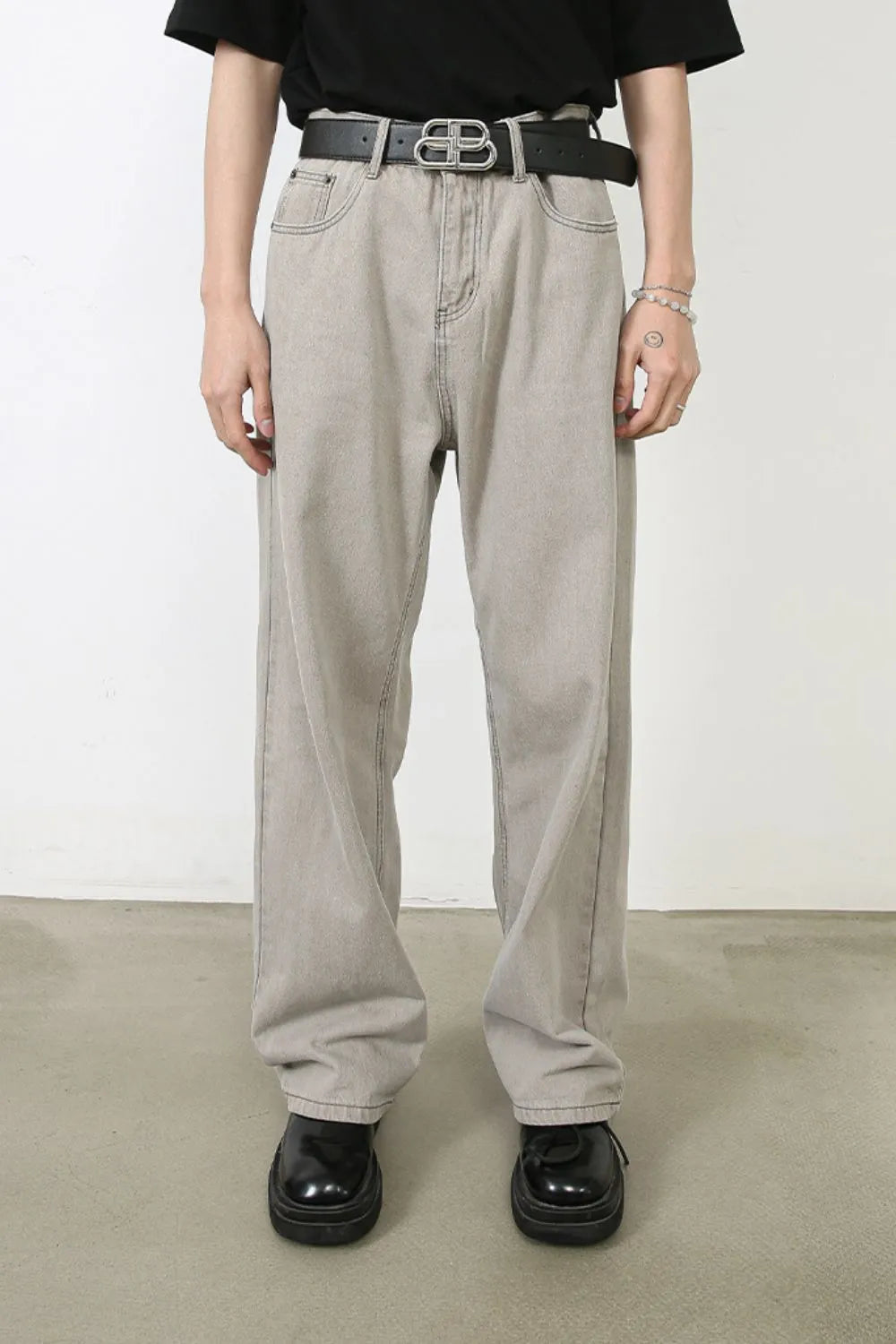 Gray wide-leg denim trousers with seam details and a relaxed fit.