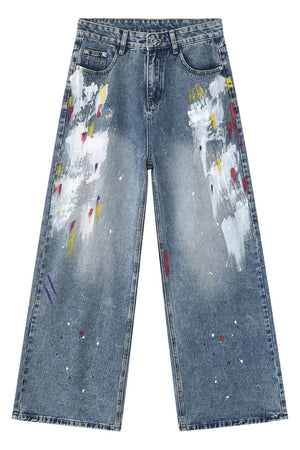 Painterly wash wide-leg denim trousers in medium blue with artistic paint splatters and brushstrokes.