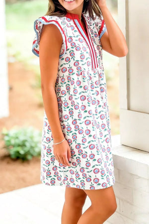 Floral dress with cap sleeves, notched neckline, and red and blue trim.