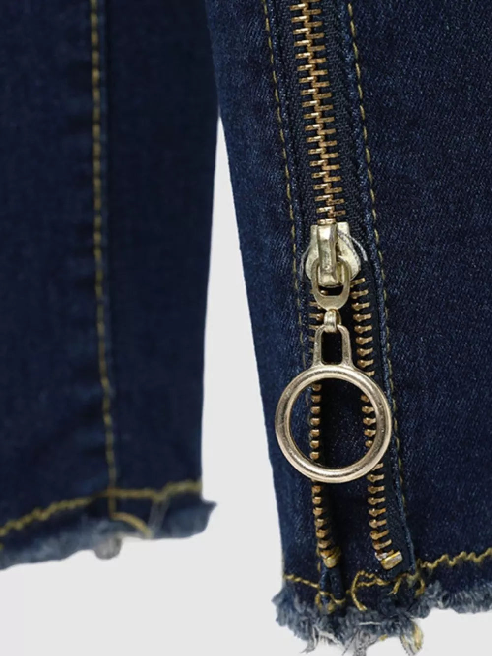 Dark blue skinny jeans with zipper detail and raw hem