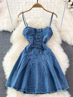 Blue denim A-line dress with lace-up corset detail and frayed hem.