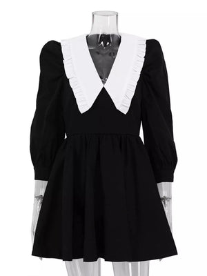 Black dress with white ruffled collar and puff sleeves