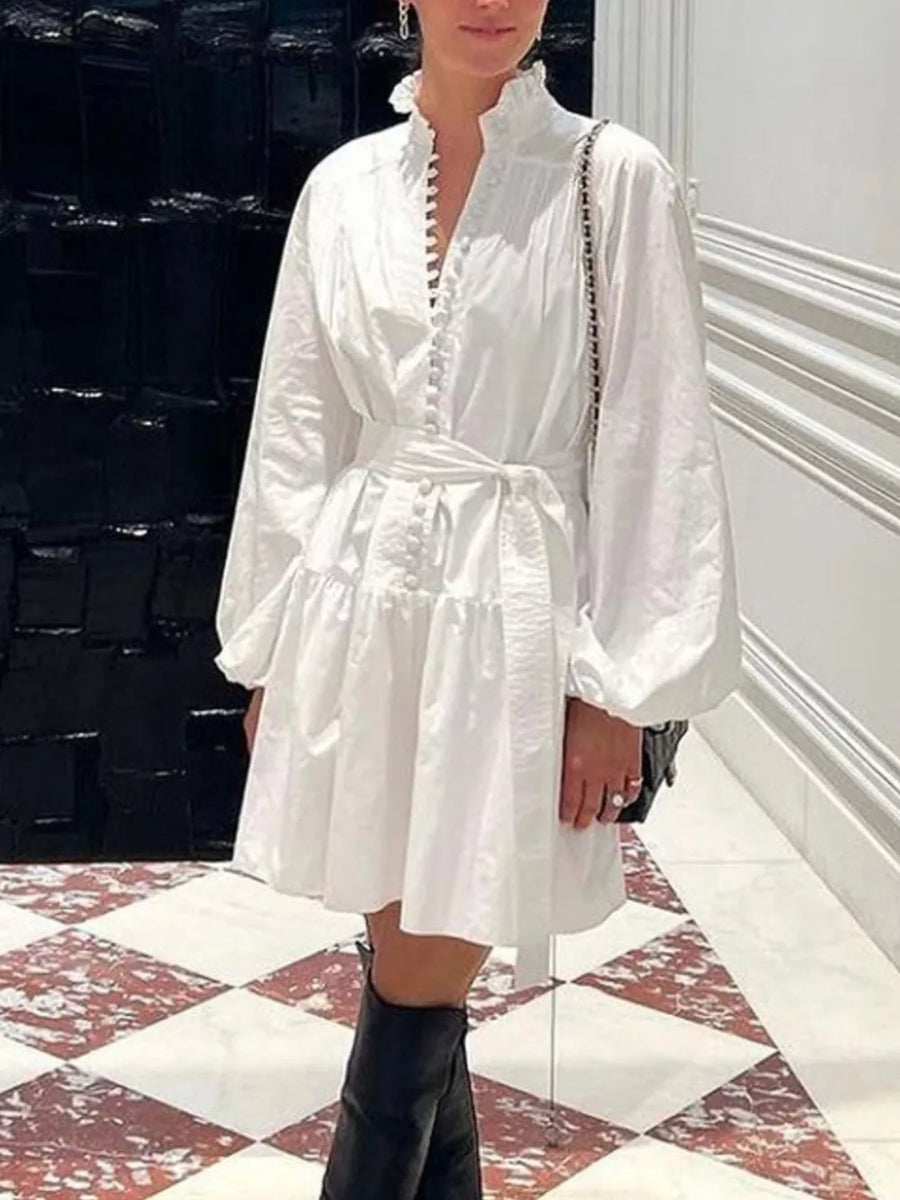 White cotton tiered mini dress with ruffled collar, balloon sleeves, and button front.