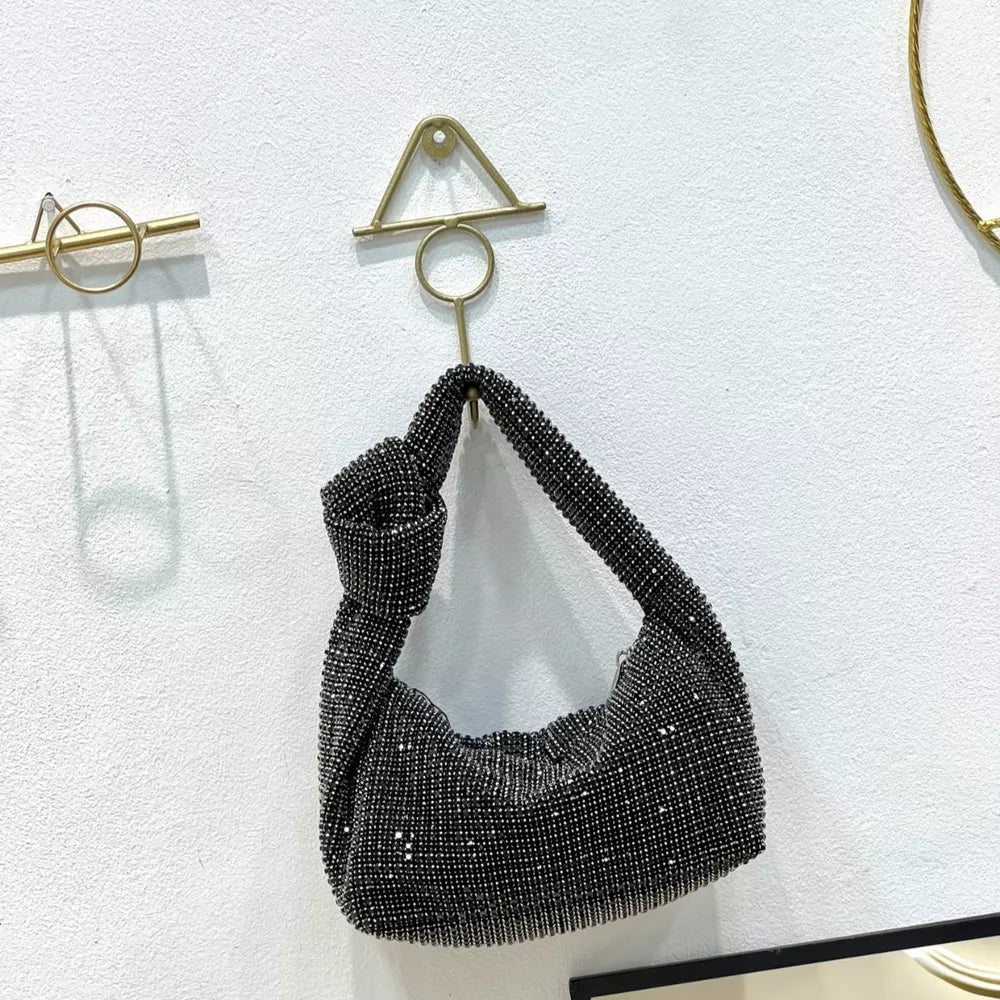 Black rhinestone crescent tote bag with knotted handle.