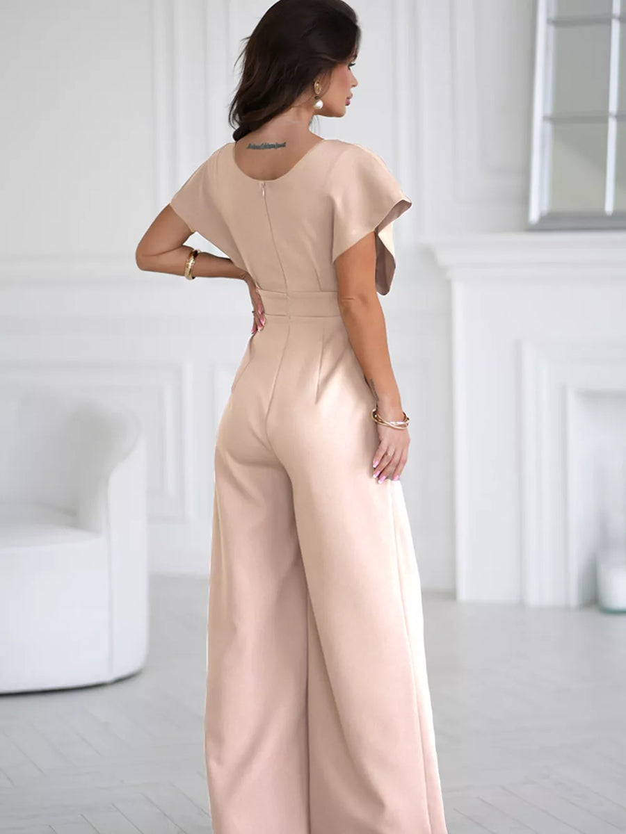 Apricot wide-leg romper with flutter sleeves and a belted waist.