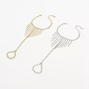 Rhinestone fringe hand chain bracelet in gold and white k with adjustable clasp and ring.