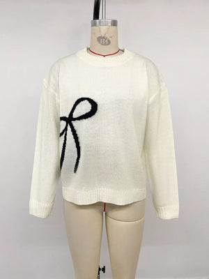 Cream knit sweater with black bow graphic, crew neck, long sleeves.