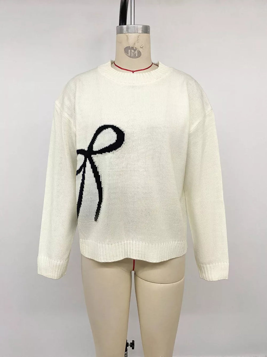Cream knit sweater with black bow graphic, crew neck, long sleeves.