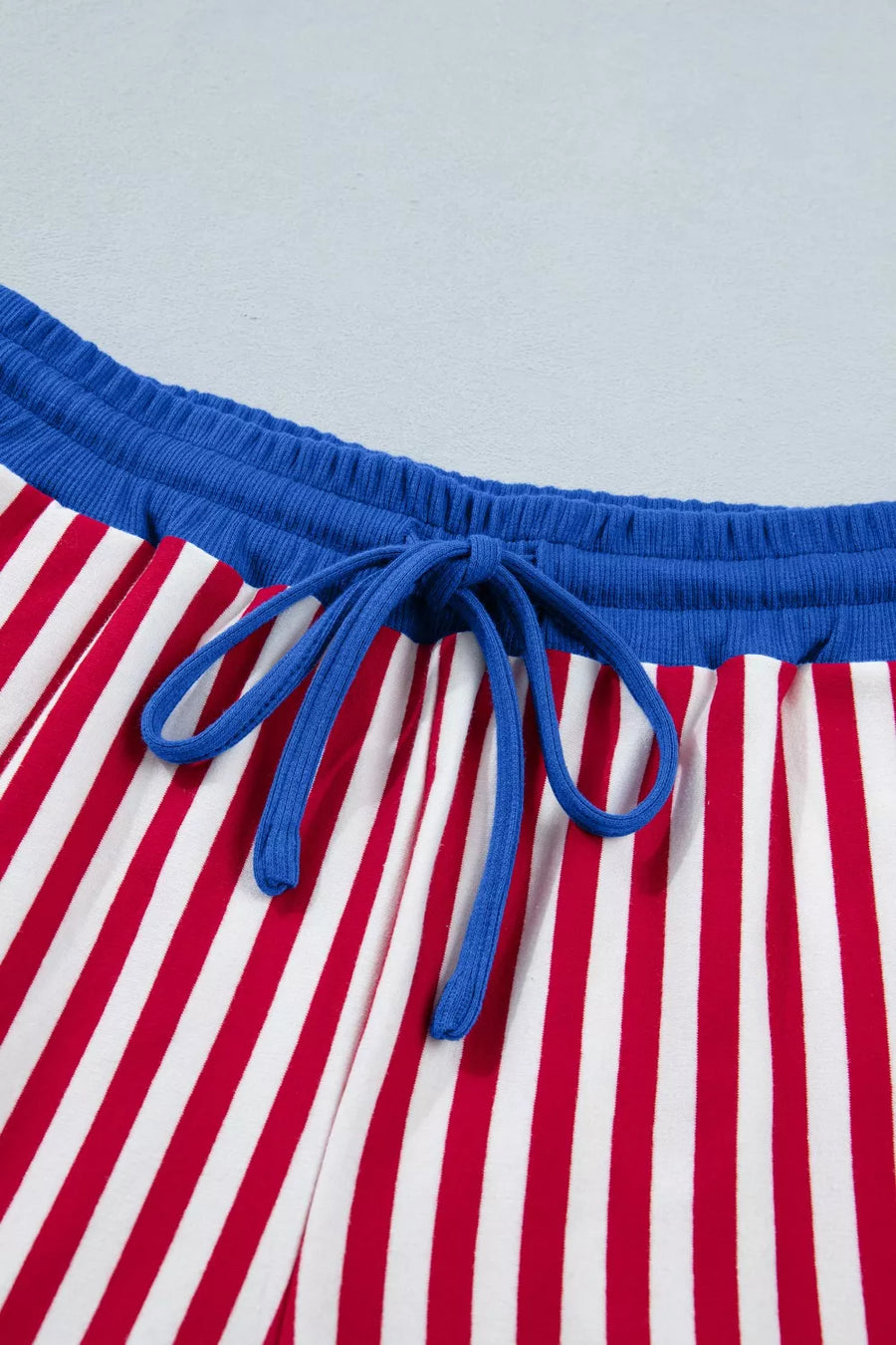Red and white striped cotton lounge pants with blue drawstring and waistband.