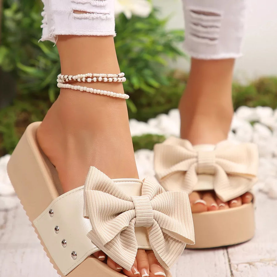 Ribbed bow accent platform sandals in white with chunky sole and studded strap detail.
