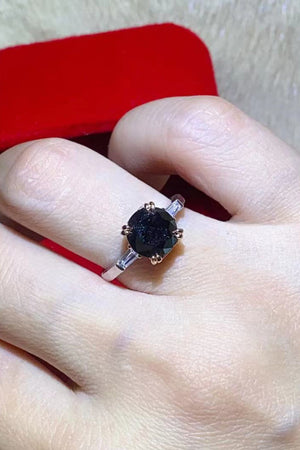 Black moissanite solitaire ring with baguette accents on a sterling silver band.
