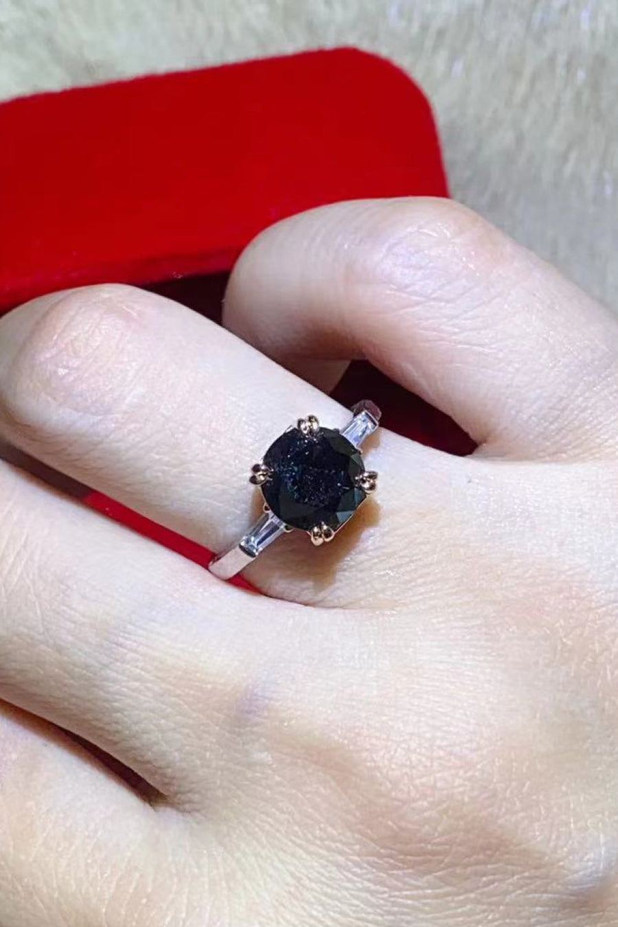 Black moissanite solitaire ring with baguette accents on a sterling silver band.