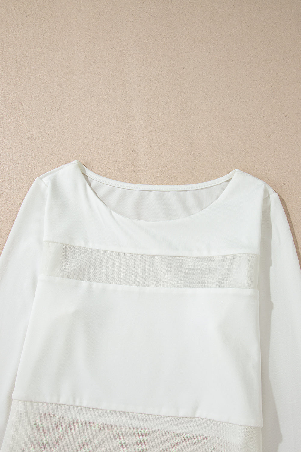 White mesh panel illusion bodysuit with long sleeves and round neckline.