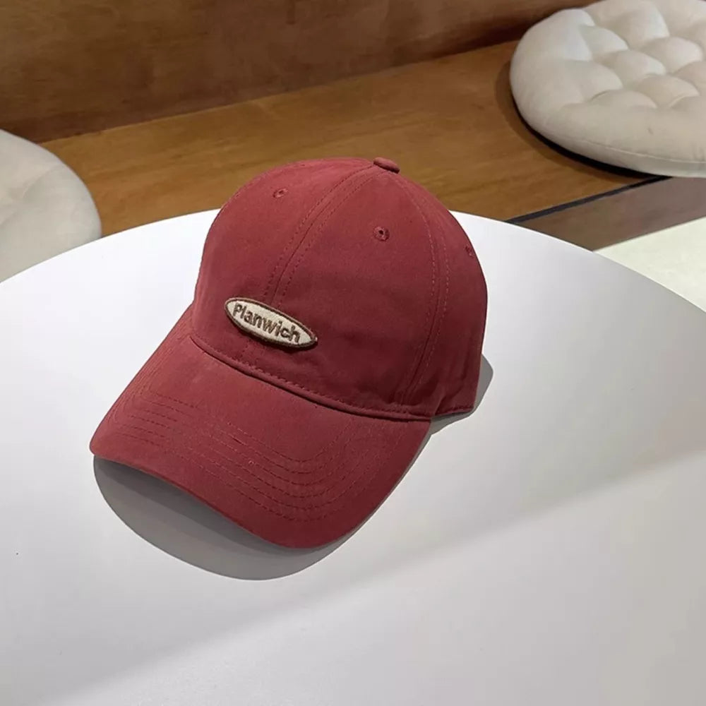 Red baseball cap with oval patch detail