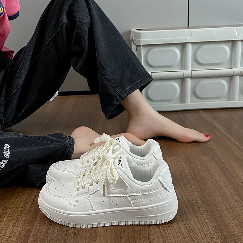 White leather sneakers with perforations and lace-up closure.