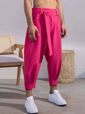 Hot pink balloon-leg wrap trousers with a tie waist, cropped length.