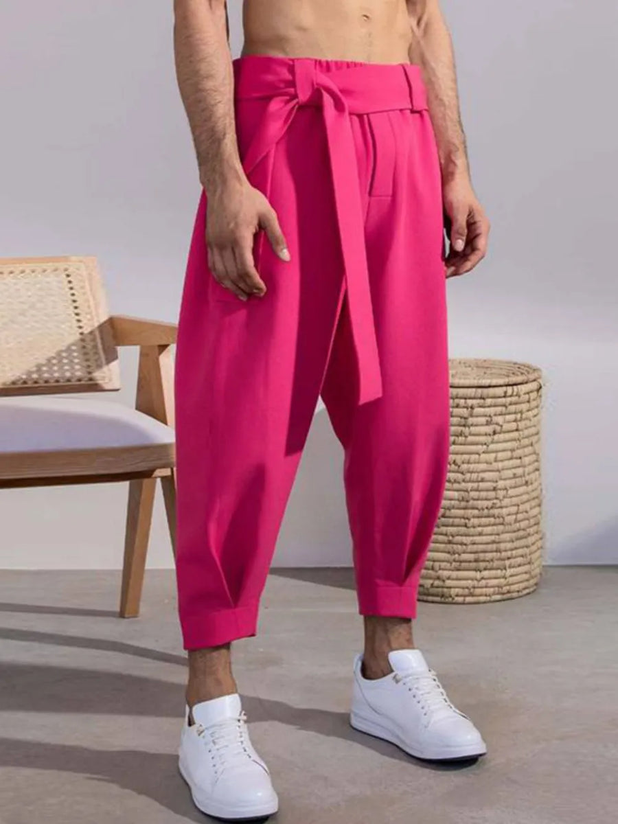 Hot pink balloon-leg wrap trousers with a tie waist, cropped length.