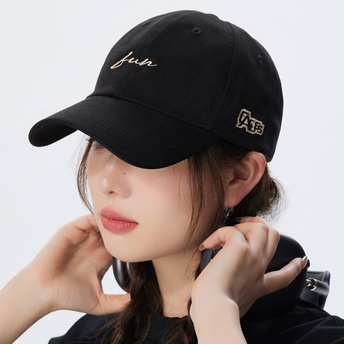 Black cotton baseball cap with embroidered "fun" text and side logo detail