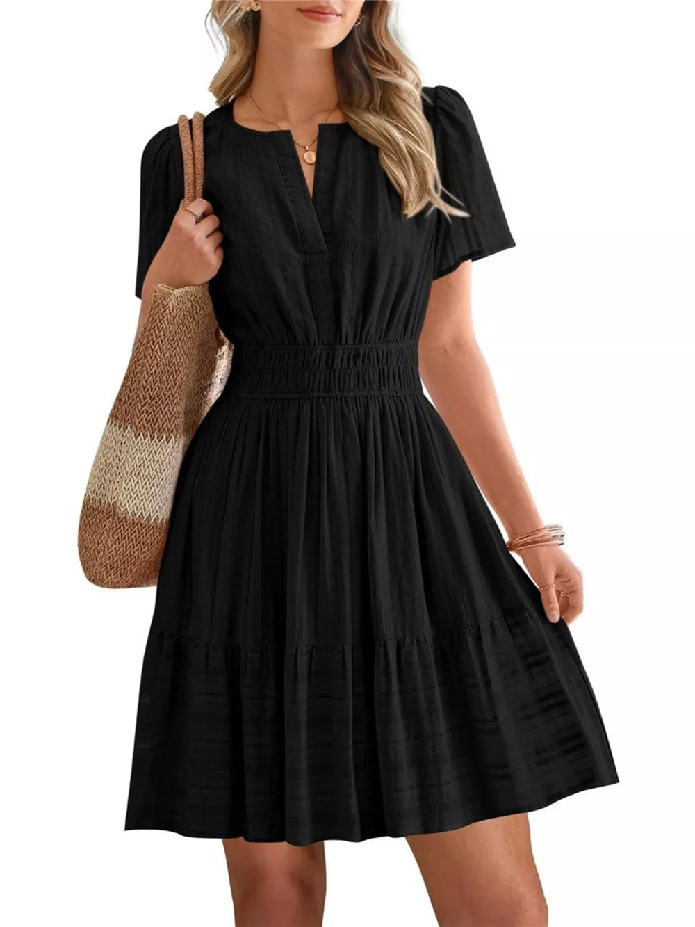 Black textured V-neck tiered dress with smocked waist and short puff sleeves.