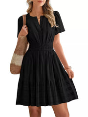 Black textured V-neck tiered dress with smocked waist and short puff sleeves.