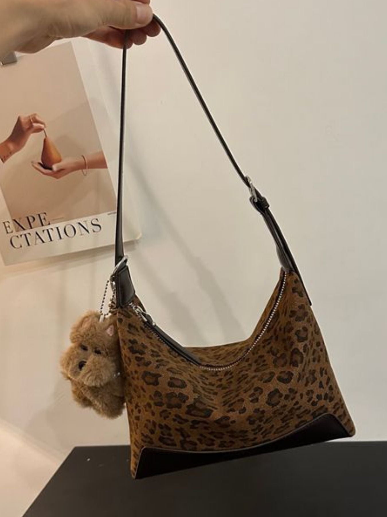 Mini crossbody bag in leopard print suede with zipper closure and teddy bear charm.