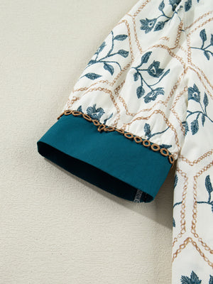 Cotton mini dress with floral print, chain pattern, polo collar, and teal cuffs.